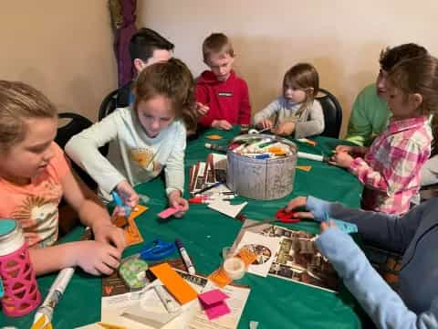 a group of children sitting around a table playing a board game