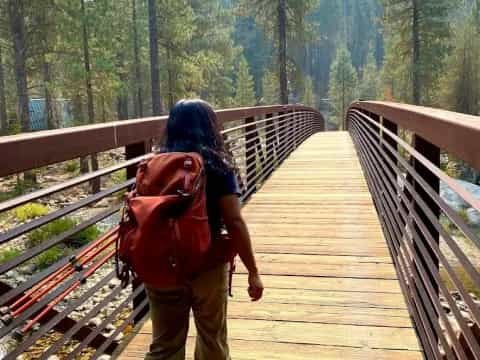 a man walking on a wooden bridge