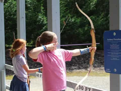 a couple of girls shooting bows