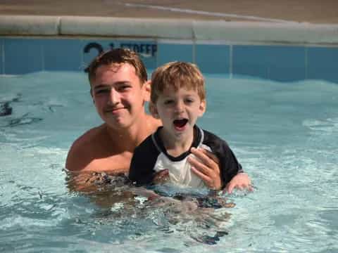 a person and a boy in a pool