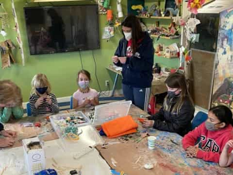 a person and several children sitting at a table