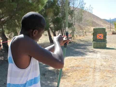 a boy shooting a bow and arrow
