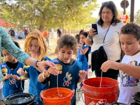 a group of people gathered around buckets of water