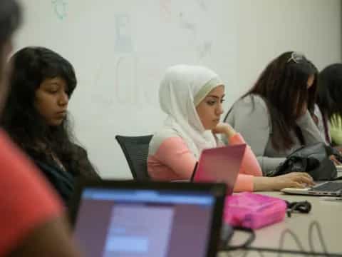 a group of women working on laptops