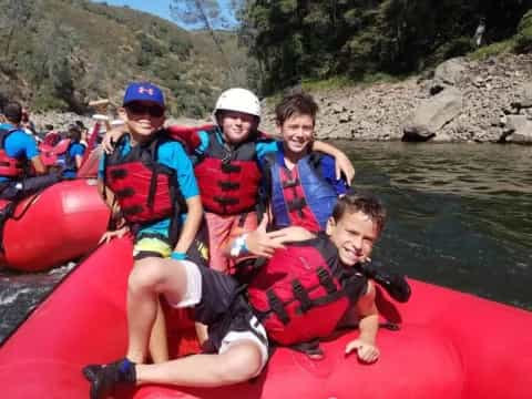 a group of people in a red raft on a river