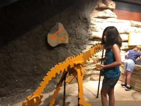 a person using a yellow hose to water a hole in a wall