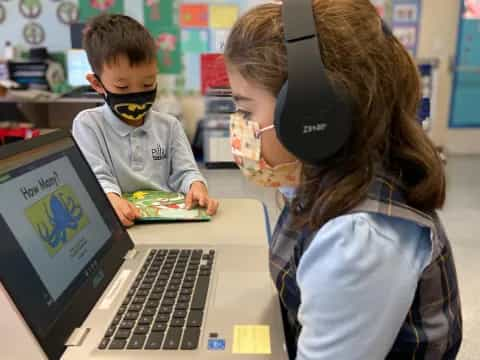 a person and a boy using a laptop