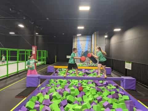 a group of people playing ping pong in a gym