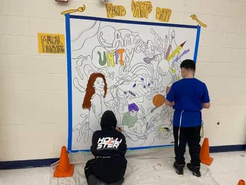 a boy painting on a wall
