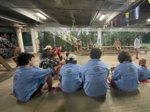 a group of people sitting on the floor in a gym