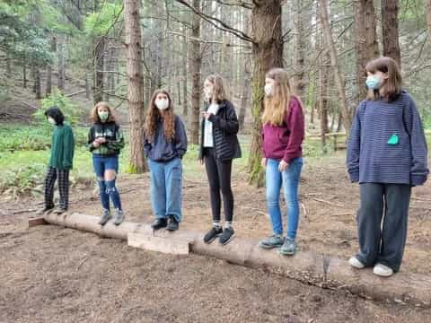 a group of people standing in a forest