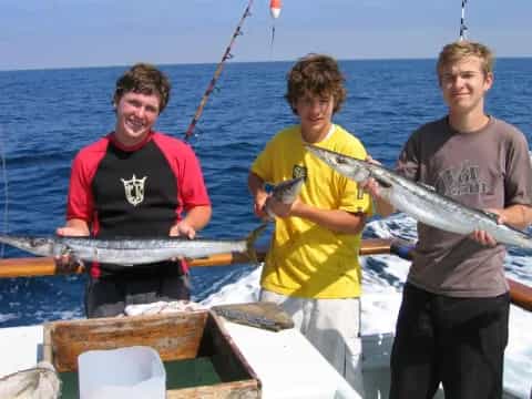 a group of men holding a fish