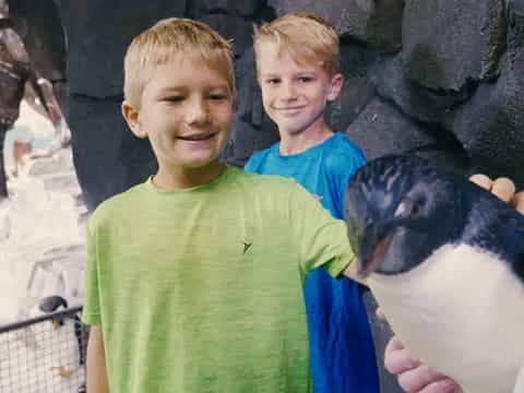 a couple of boys posing with a seal