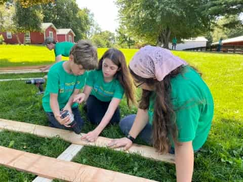 a group of people working on a wood fence