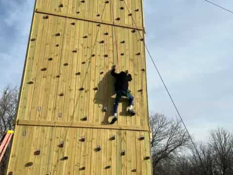 a person climbing a wooden structure