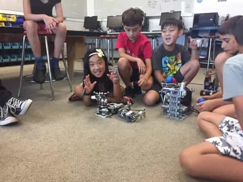 a group of kids sitting on the floor playing with toys