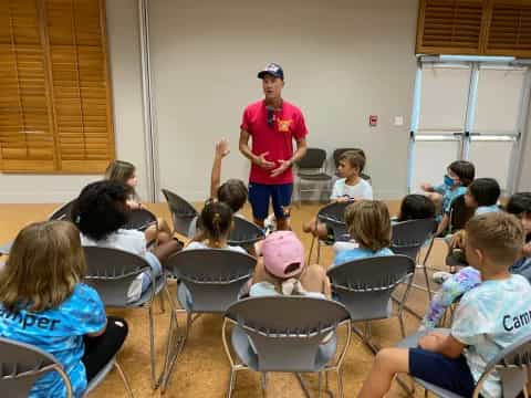 a person standing in front of a classroom of children