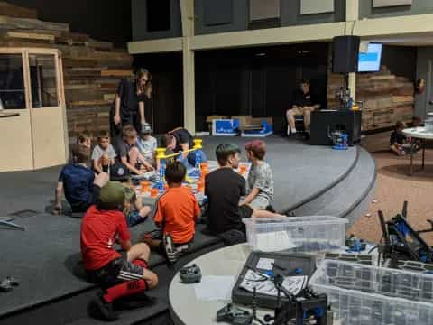 a group of people sitting on the floor with a robot