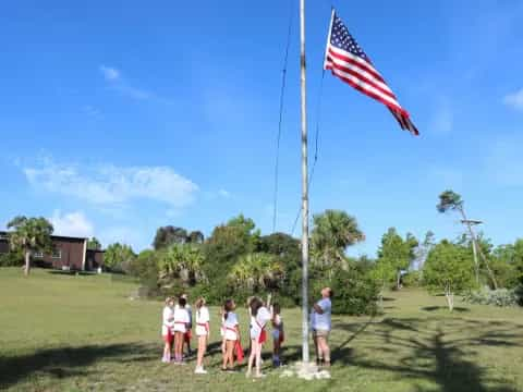 a group of people standing next to a flagpole