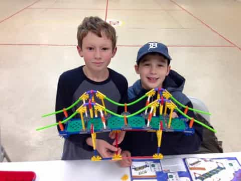 two boys holding a model airplane