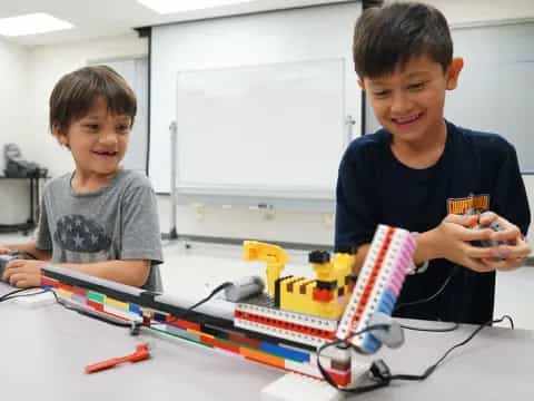 a couple of boys playing with a toy train