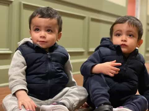 two boys sitting on the floor