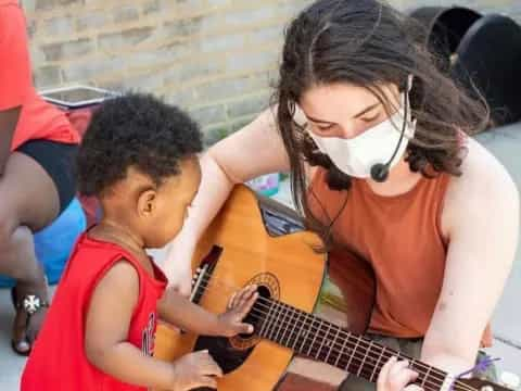 a person playing guitar with a boy