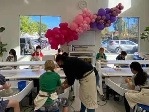 a group of people in a room with tables and balloons