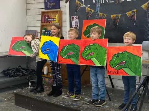 a group of children holding up colorful artwork