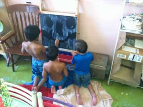 a group of kids playing on a rug in a room