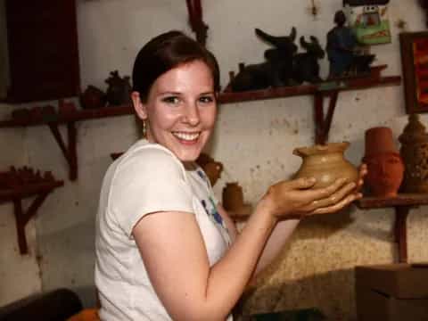 a woman holding a clay pot