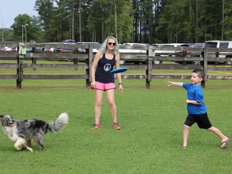 a person and a couple of kids playing frisbee