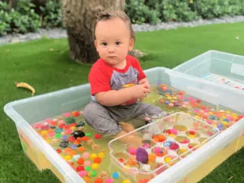 a baby playing in a plastic pool