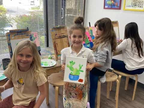 a group of children sitting at a table with a book