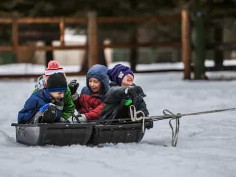 a group of kids in a sled in the snow