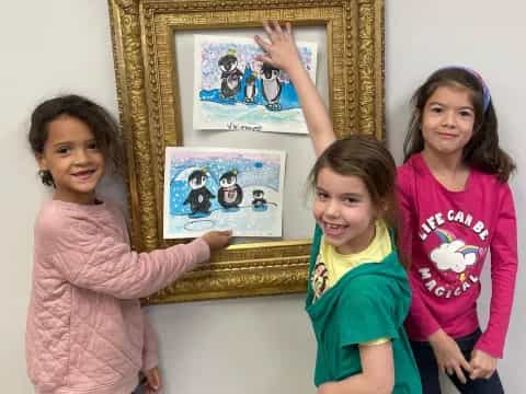 a group of girls holding up a framed picture