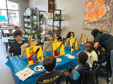 a group of people sitting around a table with colorful paper on it