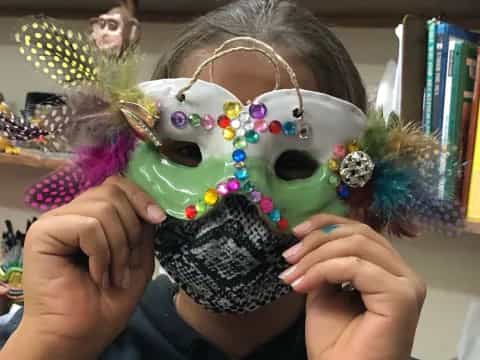 a person holding a decorated mask
