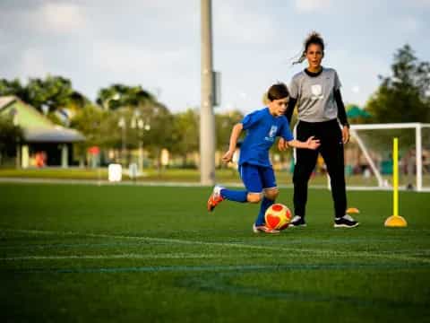 a girl kicking a football ball