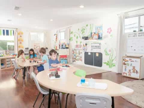 a group of children sitting at a table in a room