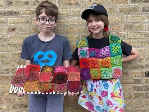 a couple of kids holding cupcakes