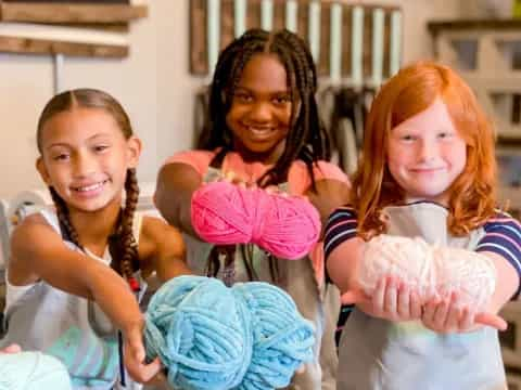 a group of girls holding a stuffed animal