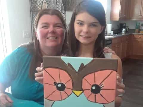 a couple of girls holding a sign