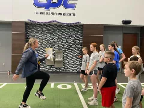 a person running on a court with a group of kids