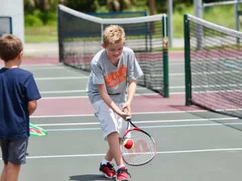 a couple of boys playing tennis