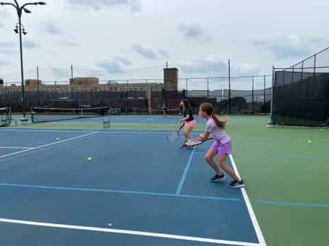 a couple of girls playing tennis