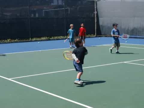 a group of people play tennis