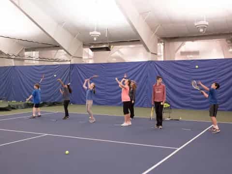 a group of people playing tennis