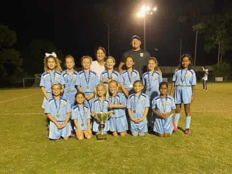 a group of people posing for a photo with a trophy