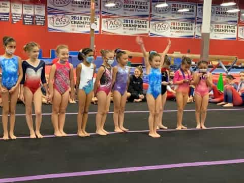 a group of women in swimsuits standing on a mat